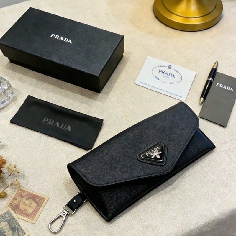 Women Bags Prada - กล่องใส่แว่นตาหนังสีดำของ Prada พร้อมโลโก้โลหะรูปสามเหลี่ยมสุดหรู กระเป๋าเก็บแว่นตาพร้อมพวงกุญแจแบบถอดได้ ป้องกันแว่นตาอย่างนุ่มนวล